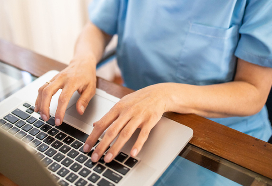 health care professional hands type on laptop computer